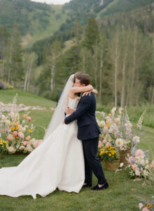 Bride and groom embrace during wedding at Beanos Cabin