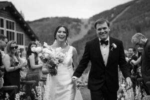 Couple leaving wedding ceremony in smiles in Colorado